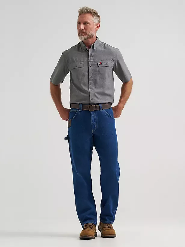 Male model wearing carpenter jeans with utility pocket detailing.