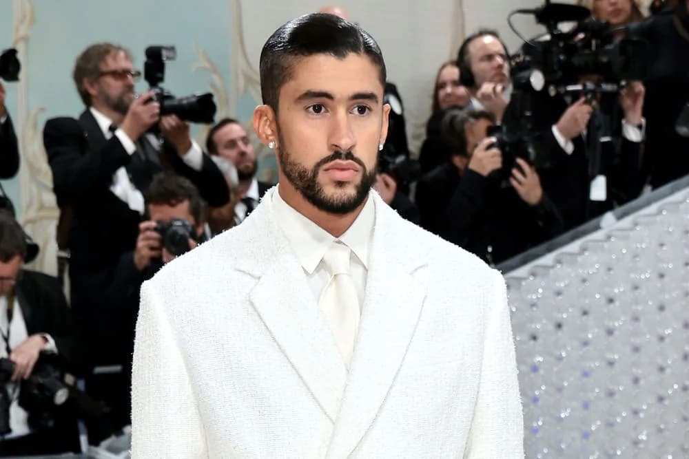 Bad Bunny wearing a backless white Jacquemus suit with a long floral train at the 2023 Met Gala.