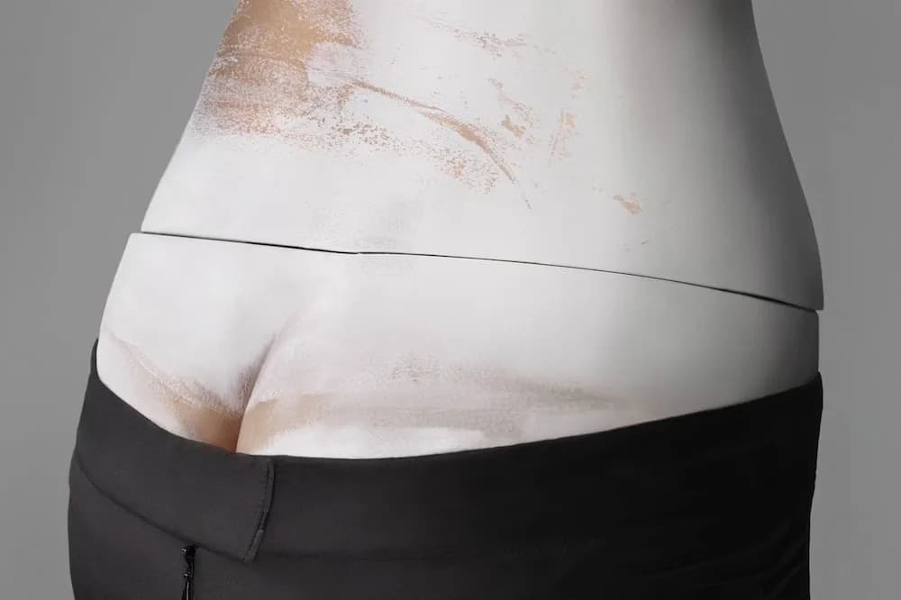 Alexander McQueen bumster design exposing the lower back above dark trousers.