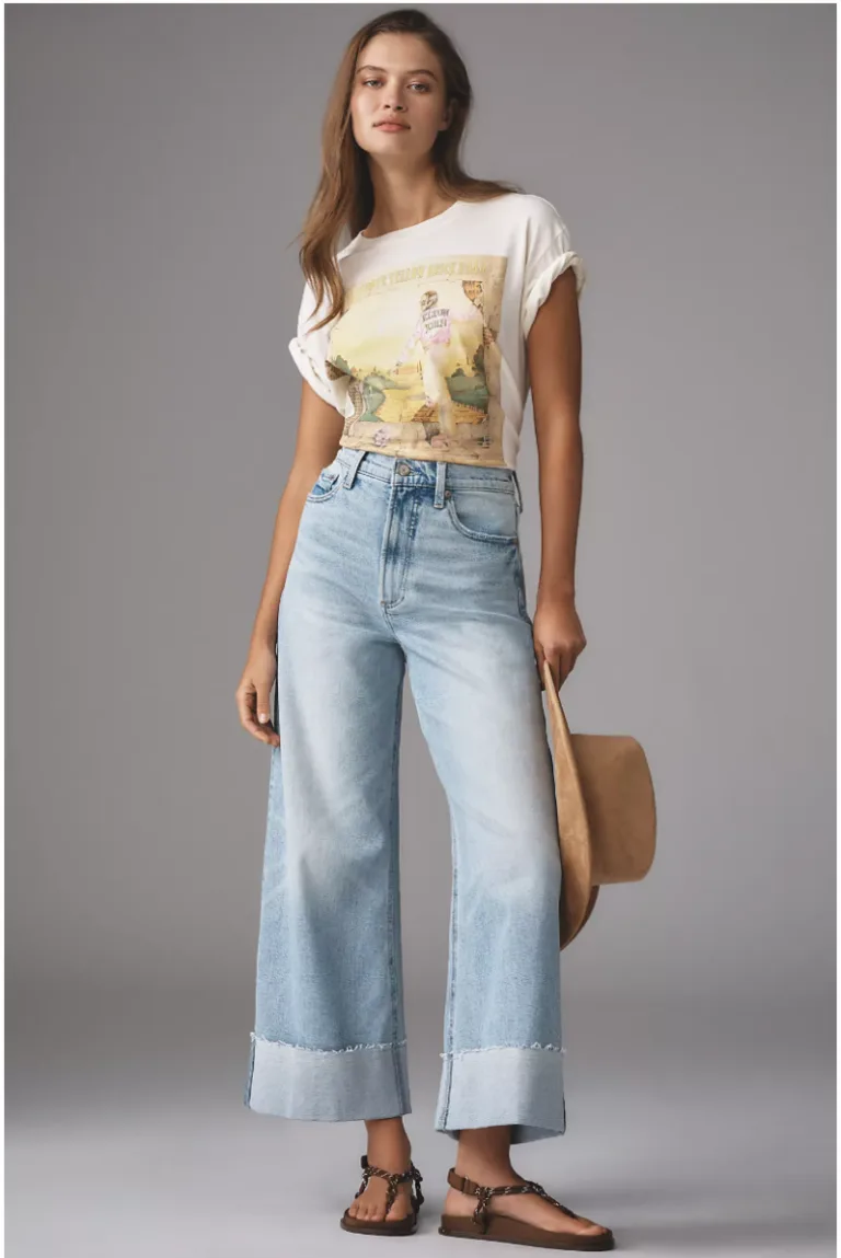 Woman wearing jeans with a thick rolled cuff at the hem.