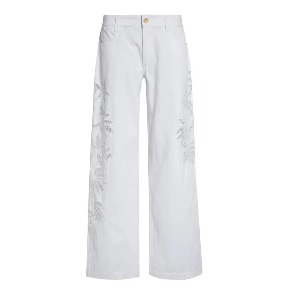 Woman wearing embellished jeans with decorative surface treatment.