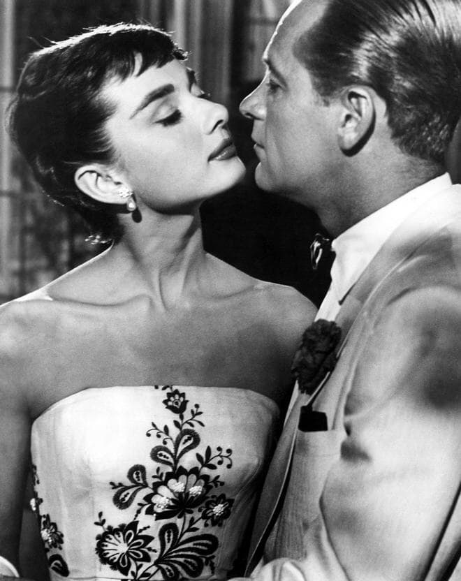 Audrey Hepburn in her iconic role in Sabrina, demonstrating the delicate, feathered pixie cut that originally propelled the style into mainstream global popularity.