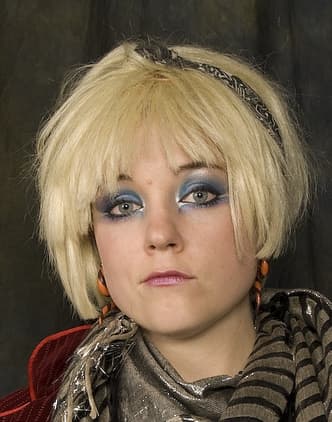 A modern visual representation of the highly layered, feathered shag cut with a prominent, face-framing fringe.